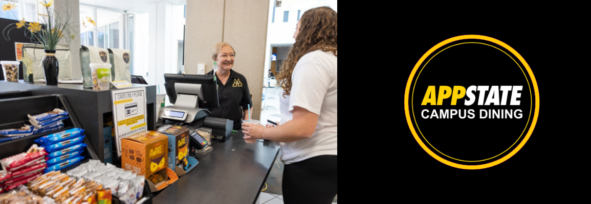 Greeter rings up student patron at register in Cascades Cafe