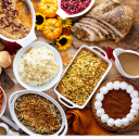A holiday meal spread with mashed potatoes, turkey, dressing, etc.