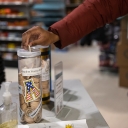 As part of Appalachian State University’s Skip the Bag program, a customer deposits a wooden nickel received for choosing to forgo a plastic bag on a purchase from The Market at the University Bookstore. At the end of each semester, Campus Services tallies the wooden nickels that are dropped into canisters for university organizations, such as this one for App State’s Student Veterans Association, and converts them to monetary contributions that are then made to the organizations. Photo by Chase Reynolds