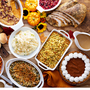 A holiday meal spread with mashed potatoes, turkey, dressing, etc.