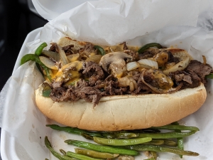 Shaved Ribeye with grilled veggies in a sub-style bun with grilled green beans on the side