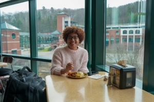 A student enjoys a traditional Thanksgiving meal at a table in the dining hall