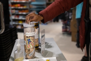 As part of Appalachian State University’s Skip the Bag program, a customer deposits a wooden nickel received for choosing to forgo a plastic bag on a purchase from The Market at the University Bookstore. At the end of each semester, Campus Services tallies the wooden nickels that are dropped into canisters for university organizations, such as this one for App State’s Student Veterans Association, and converts them to monetary contributions that are then made to the organizations. Photo by Chase Reynolds