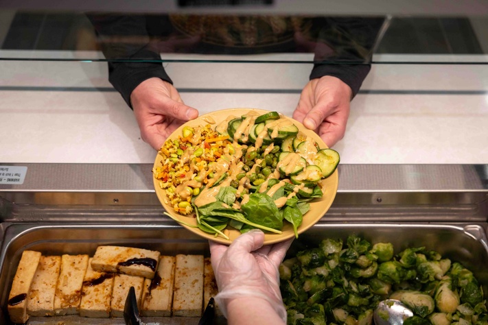 Server handing plate of veggies to customer