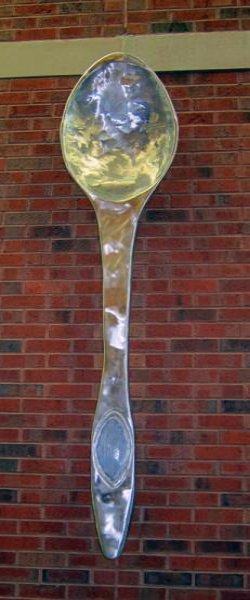 Metal spoon sculpture hanging on wall of dining hall